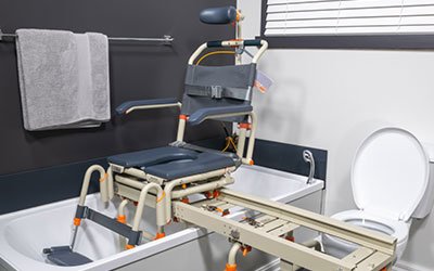 Photo of a bathtub chair designed by Showerbuddy, featuring a transfer bench extending over the tub to aid individuals in safely entering and exiting the bathtub.