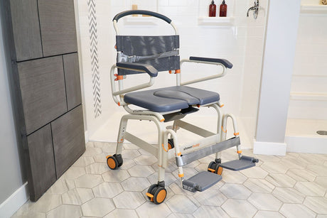 Showerbuddy shower chair with safety straps and durable wheels, designed for comfortable and accessible showering, showcased in a clean, white-tiled bathroom setting.