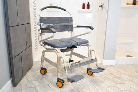 Showerbuddy chair positioned in a bright bathroom, featuring armrests and footrests for stability and comfort, designed to provide a secure showering experience for users with limited mobility.