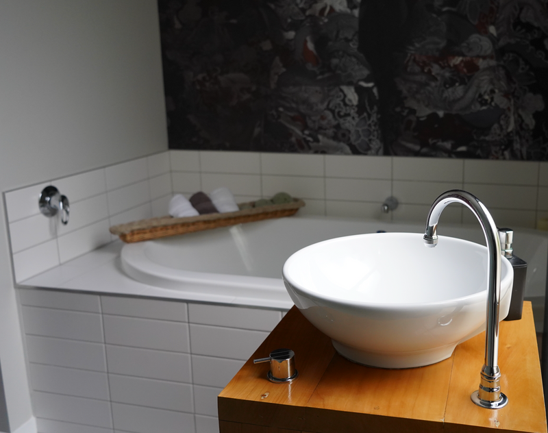 Modern bathroom interior with a vessel sink on a wooden countertop, illustrating that Showerbuddy chairs are designed to complement and fit a variety of bathroom styles.