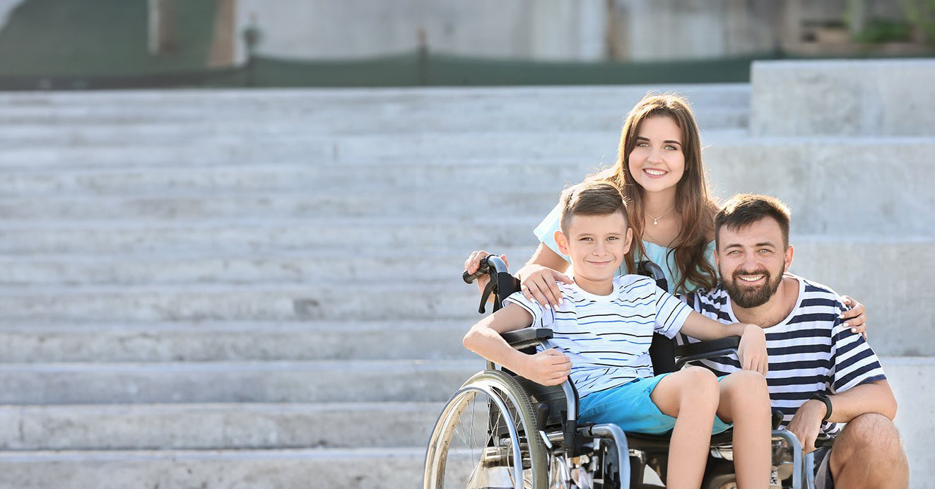 Banner image of a smiling family, with a child in a wheelchair, for a guide on families supporting a disability, advising consultation with healthcare professionals for specific guidance.