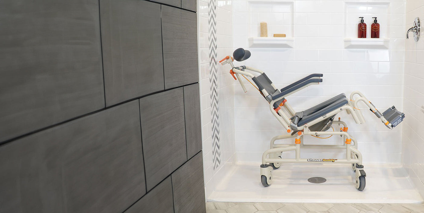 Promotional image of a Showerbuddy shower chair, presented as an all-in-one shower and bathroom mobility solution, with the chair shown against a tiled bathroom wall.