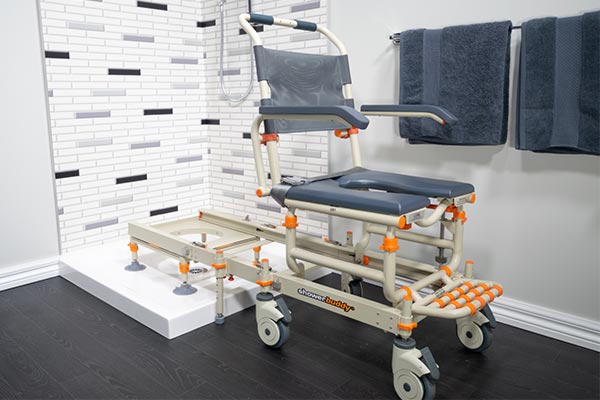 Image of MODEL SB1 "ShowerBuddy", featuring a modular chair and track system designed for bathroom mobility, displayed in a modern bathroom setting.