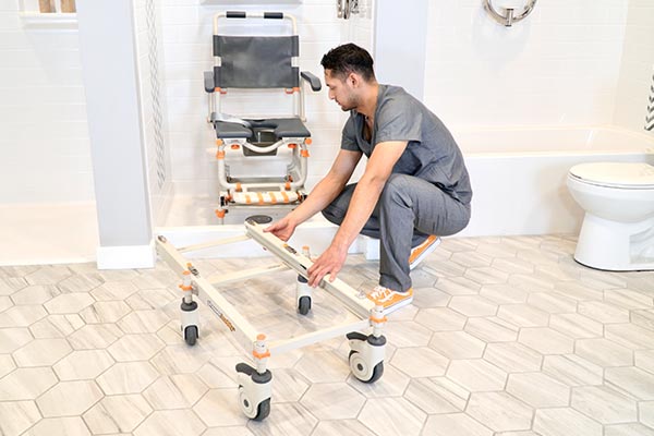 Image for a buying guide featuring a man adjusting a Showerbuddy transfer system in a bathroom setting, suggesting personal assistance with product selection.