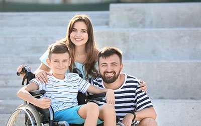 A family portrait with a child in a wheelchair, promoting a guide about family life and managing disabilities, catering to needs from young children to adults.