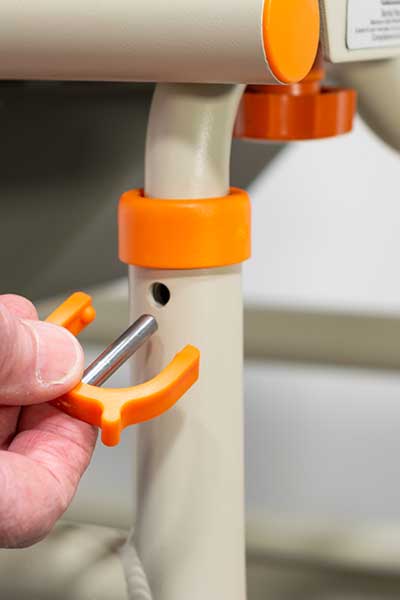 Image showing a hand adjusting the height setting on a Showerbuddy chair, highlighting the chair's adjustable features for user customization.