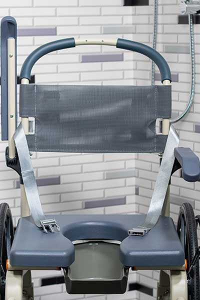 Image focused on the safety belt and backrest of a Showerbuddy chair, highlighting the safety features designed for stable and secure bathing.