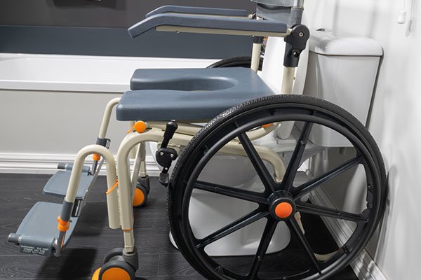 Showerbuddy wheelchair with large wheels and adjustable toilet riser, emphasizing the convenience and adaptability for users with mobility needs.